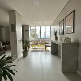 Ambiente interno com piso claro e grandes janelas em uma residência.