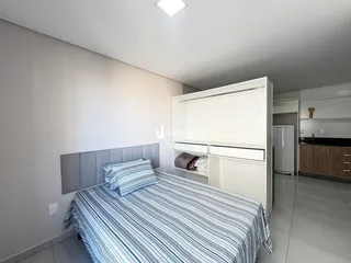 Quarto com cama e armário branco.
