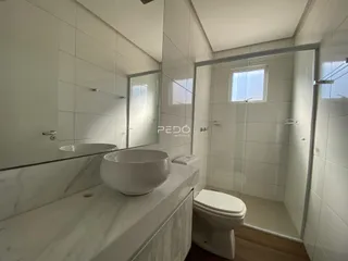 Banheiro moderno com revestimento de azulejos brancos e bancada de mármore.