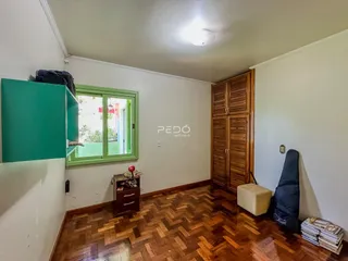 Sala de um imóvel com piso de madeira e armários em Lajeado, Brasil.
