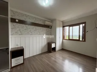 Ambiente interno de uma sala com piso de madeira e parede decorada.