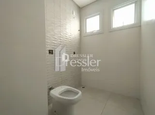 Foto interna de um banheiro com paredes brancas e azulejos brancos.