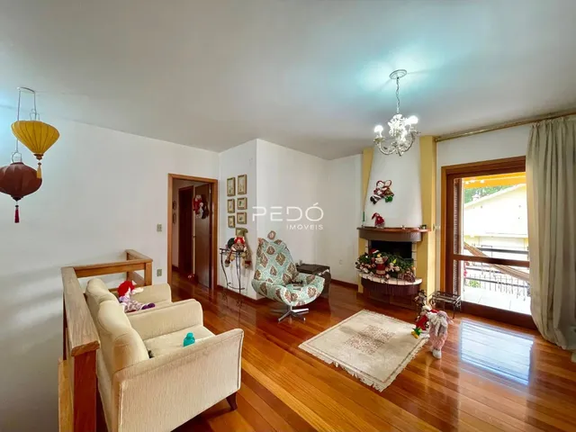 Sala de estar com piso de madeira e lareira em imóvel no Brasil.