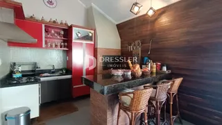 Cozinha com armários vermelhos e bancada escura em um imóvel no Brasil.