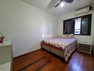 Quarto com piso de madeira e janela.