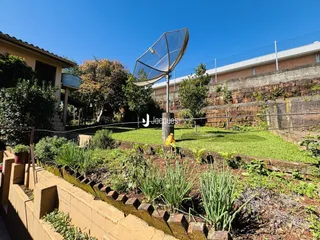 Paisagem externa do terreno com jardim e cerca.