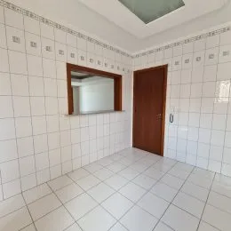 Interior de um cômodo com piso e paredes brancas.