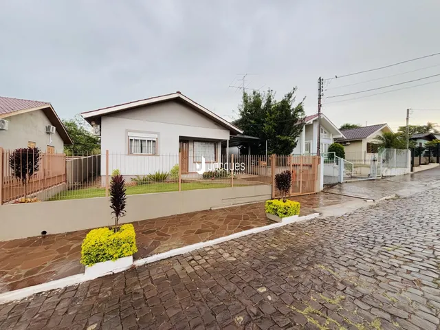 Fachada de uma casa em Lajeado, Brasil, com cerca e jardim na frente.