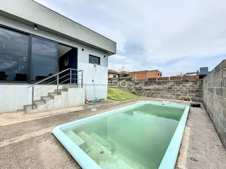 Vista externa de uma residência com piscina e muro de contenção.