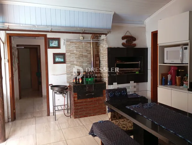 Interior de uma sala com lareira e portas abertas em uma residência.