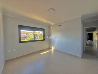 Sala de estar clara com grande janela de vista para o exterior.