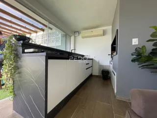Vista da cozinha com bancada e grande janela de vidro.