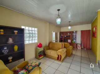 Sala de estar com sofá e estantes de madeira em um imóvel no Brasil.