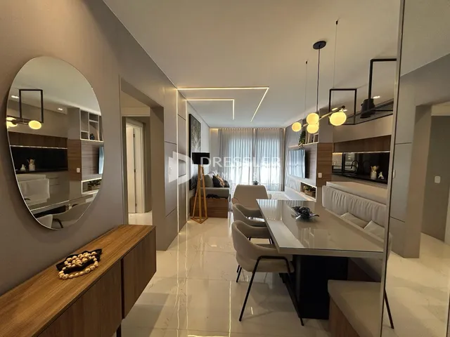 Sala de estar moderna com piso claro e grandes espelhos.