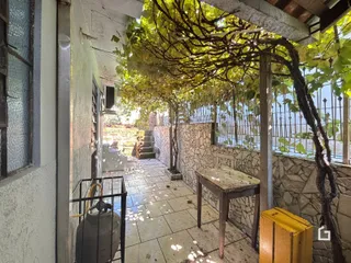 Um pátio externo com parede de pedra e vegetação.