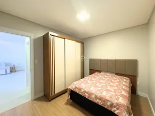 Quarto com armário de madeira e piso de madeira claro.