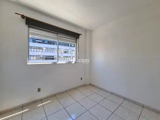 Interior de um cômodo com paredes brancas e piso de cerâmica.