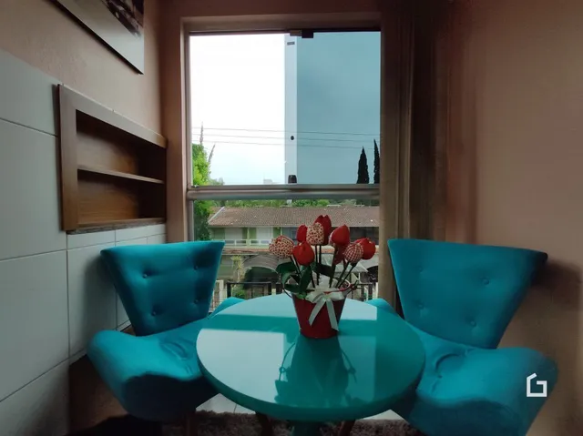 Uma sala de estar com móveis azuis e uma grande janela.