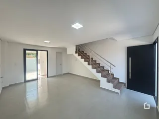 Ambiente interno com piso claro e escadaria.