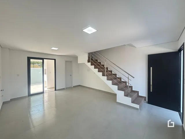 Ambiente interno com piso claro e escadaria.
