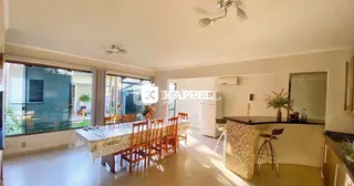Sala de jantar com mesa e grandes janelas.