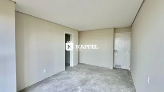 Uma foto de um cômodo vazio com paredes brancas e piso de concreto.