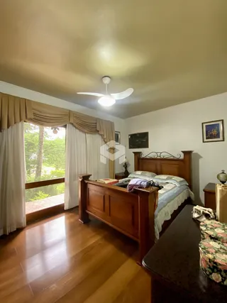 Quarto com cama de madeira e vista para o exterior.
