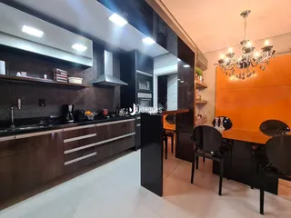 Vista da cozinha moderna com armários escuros e iluminação em Lajeado.