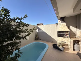 Vista da área externa com piscina e parede de alvenaria em Lajeado.