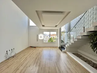 Sala de estar com piso de madeira clara e escadaria moderna.