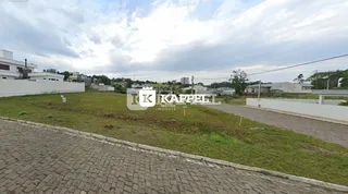 Vista externa de um terreno com grama e área pavimentada.