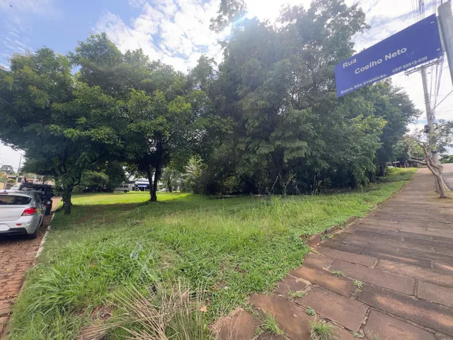 Vista externa da propriedade mostrando gramado e árvores ao lado de uma rua.