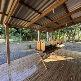 Deck de madeira com estrutura de pergolado em área externa.
