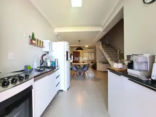 Cozinha moderna com armários brancos e eletrodomésticos em um imóvel em Lajeado, Brasil.