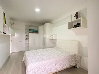 Quarto com cama e armários brancos em um imóvel.