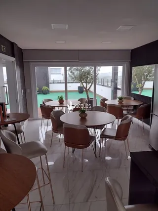 Sala de jantar com mesa redonda e cadeiras em um imóvel em Lajeado.