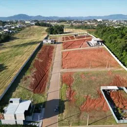 Vista aérea de um terreno aberto com vegetação seca e delimitação de propriedade.