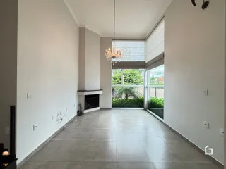 Sala de estar ampla com piso de cerâmica e grande janela com vista para o exterior.