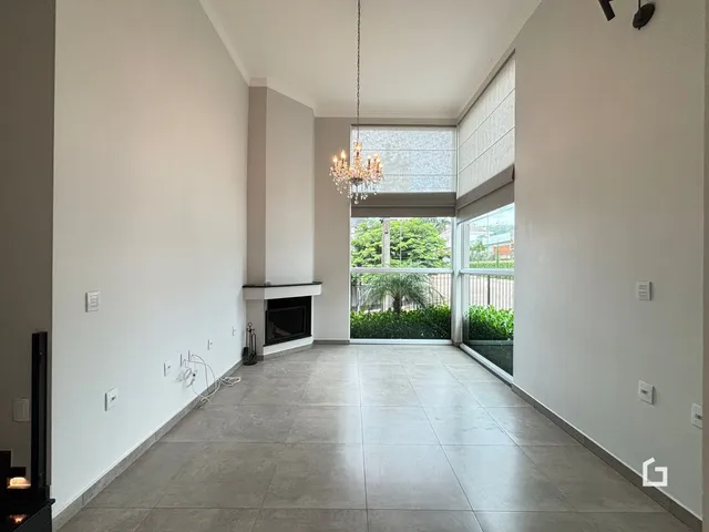 Sala de estar ampla com piso de cerâmica e grande janela com vista para o exterior.