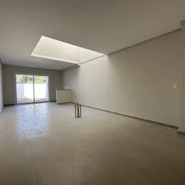 Foto de um ambiente interno amplo e vazio com piso claro.