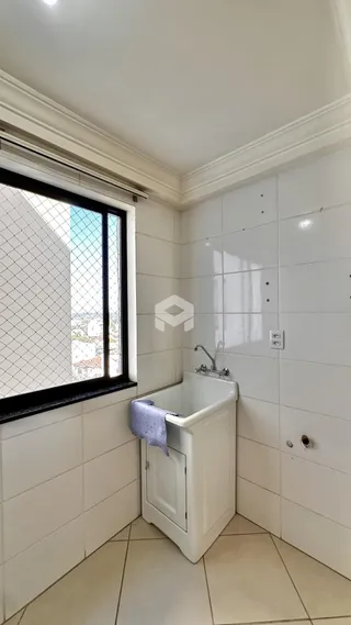 Banheiro com revestimento cerâmico branco nas paredes e piso.