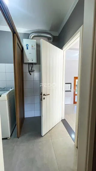 Hall de entrada com portas brancas e piso claro.