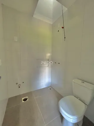 Foto de um banheiro com piso cerâmico e paredes brancas.
