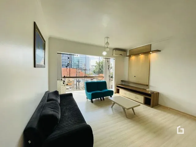 Sala de estar com sofá e piso de madeira clara.