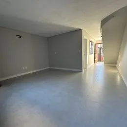 Foto de um ambiente interno amplo com paredes cinzas e piso claro.