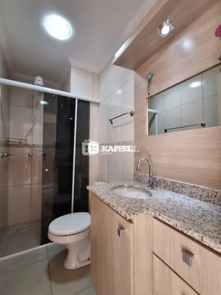Foto de um banheiro moderno com louças brancas e revestimento claro.
