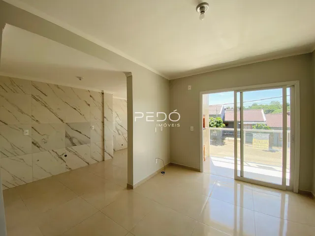 Sala de estar com piso claro e parede decorada com mármore na residência.