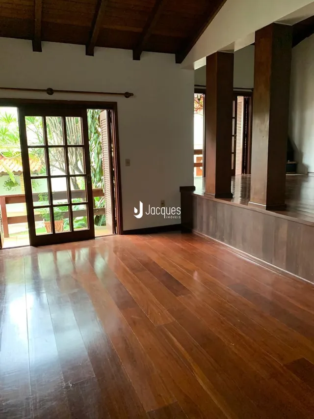 Sala de estar com piso de madeira e portas de vidro.