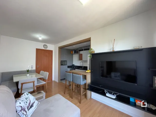 Ambiente interno de sala de estar e jantar com piso de madeira clara.