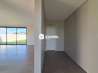 Hall de entrada com paredes brancas e piso claro.